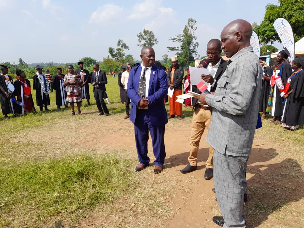 Madada standing with some men during a ceremony